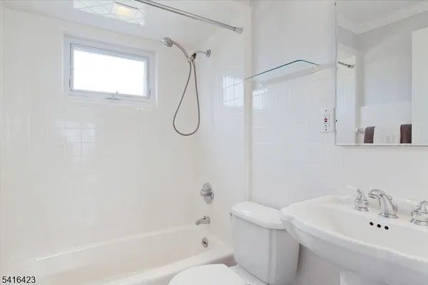a bathroom with a white bath tub a sink and a shower