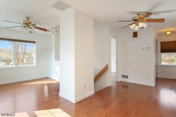 a view of a livingroom with wooden floor and a ceiling fan