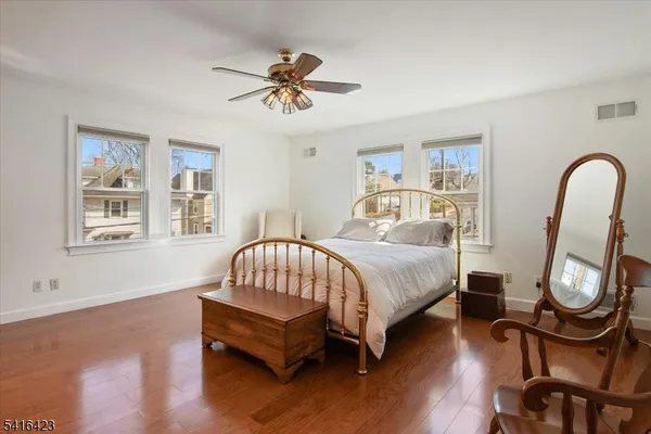 a spacious bedroom with a bed chairs and window