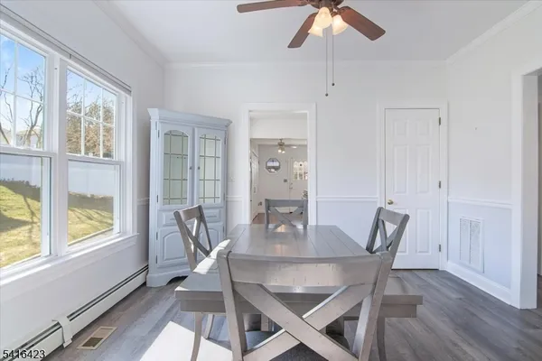 a dining room with furniture a chandelier and wooden floor