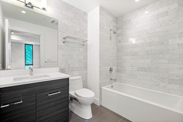 a bathroom with a bathtub shower sink mirror and toilet
