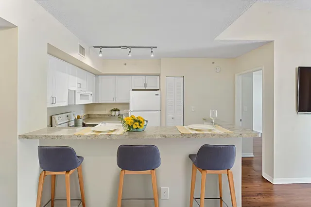 a kitchen with a sink a stove and chairs