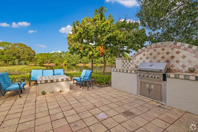 a view of a patio with a table chairs and a yard