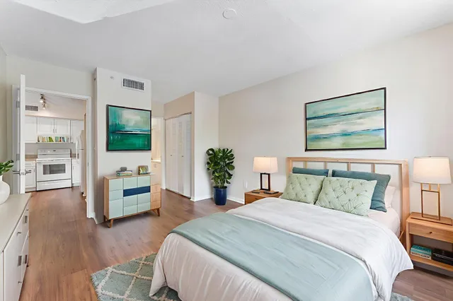 a bedroom with a large bed and a wooden floor