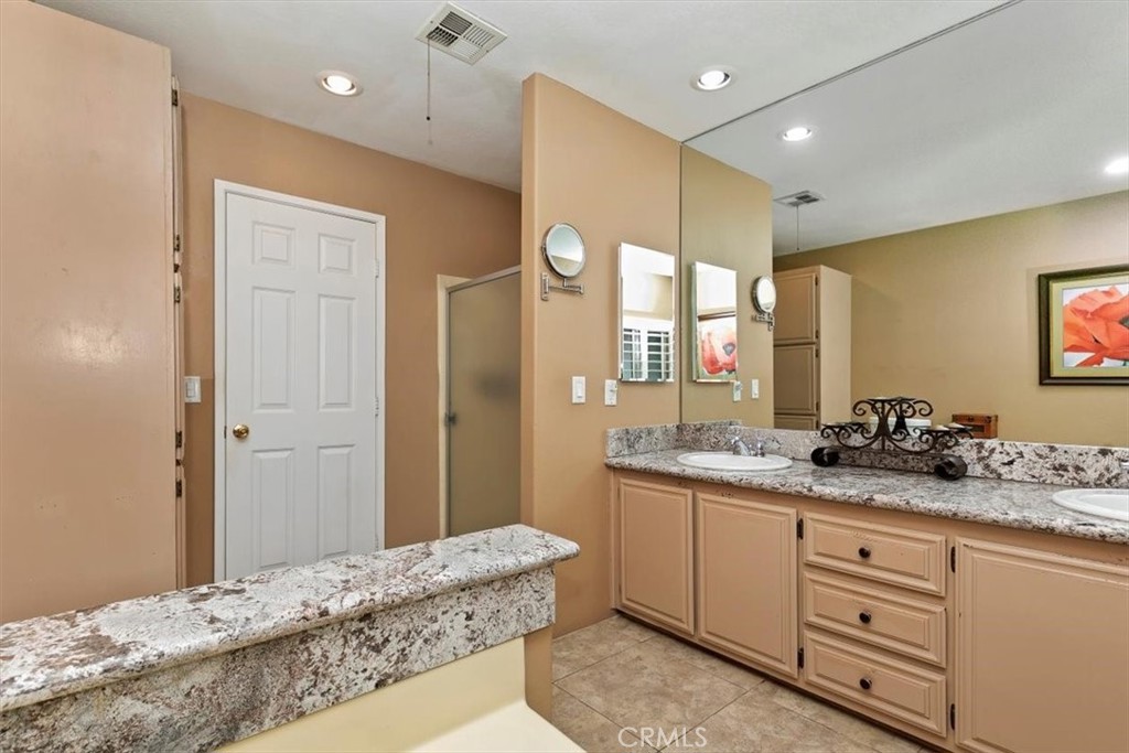 46618 Madison Street, Unit 85 Indio, CA 92201 - Photo 48 of 50 a spacious bathroom with a granite countertop sink mirror and double
