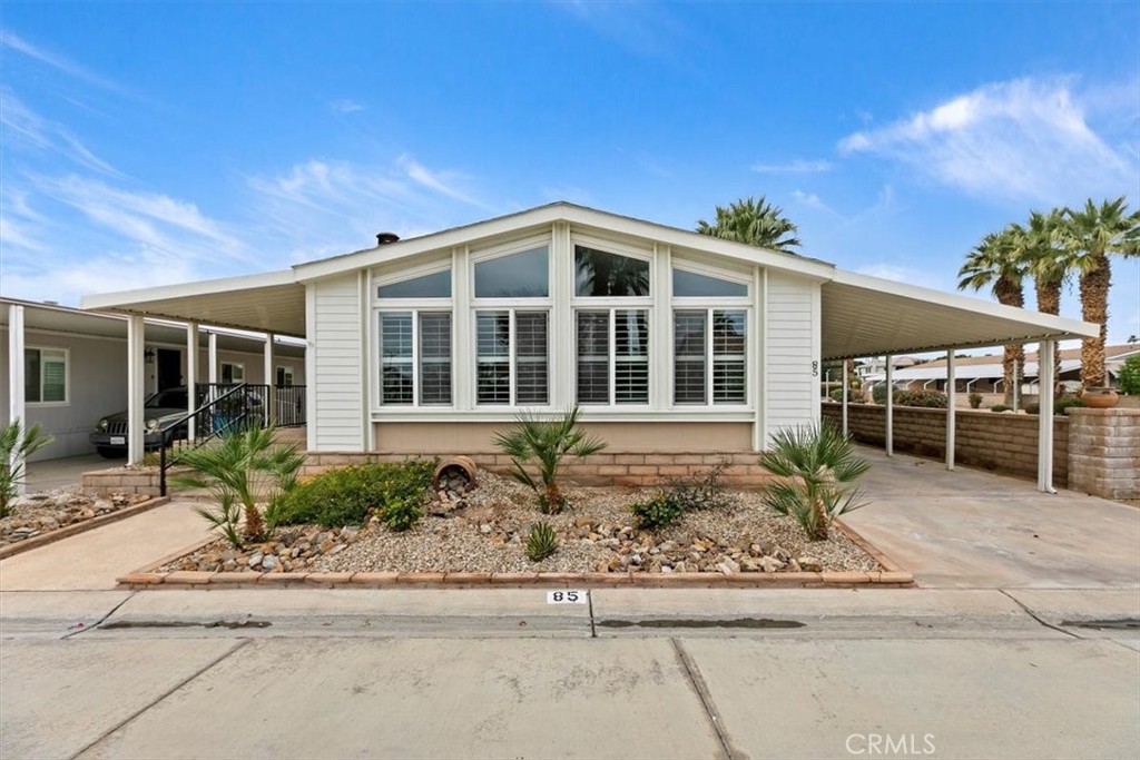 46618 Madison Street, Unit 85 Indio, CA 92201 - Photo 10 of 50 a front view of a house with a garden and plants