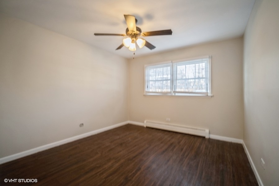 340 Waukegan Road, Unit 3 Glenview, IL 60025 - Photo 4 of 6 an empty room with wooden floor fan and windows