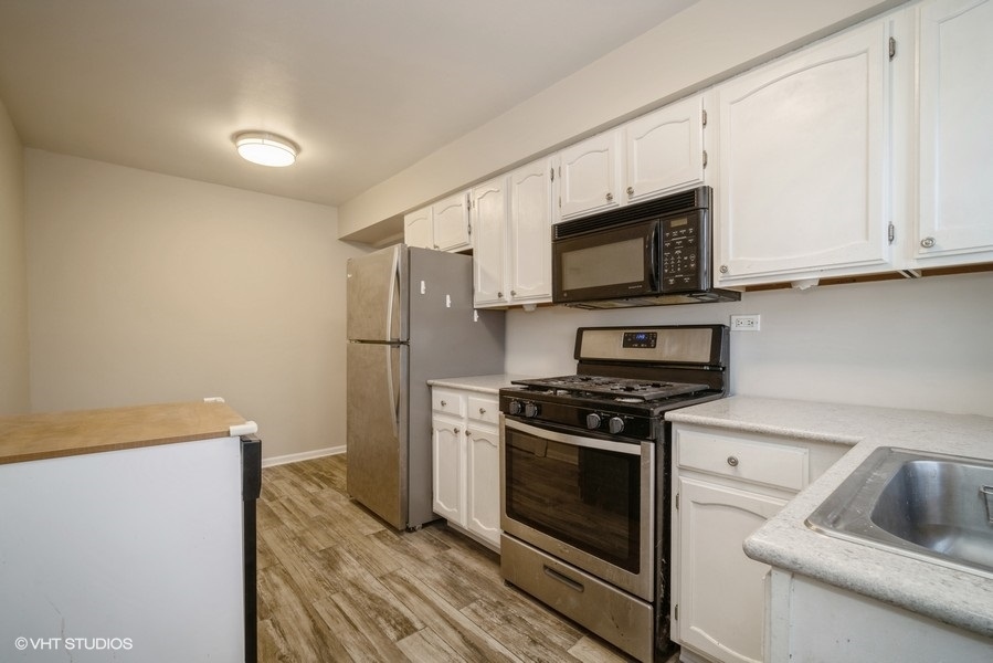340 Waukegan Road, Unit 3 Glenview, IL 60025 - Photo 5 of 6 a kitchen with stainless steel appliances a stove a microwave and a refrigerator