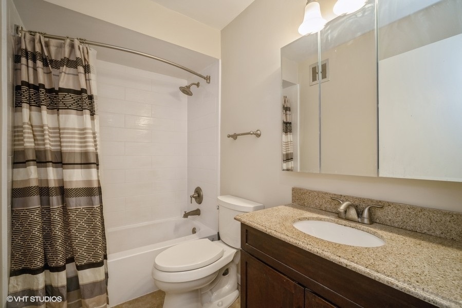 340 Waukegan Road, Unit 3 Glenview, IL 60025 - Photo 6 of 6 a bathroom with a granite countertop sink toilet and shower