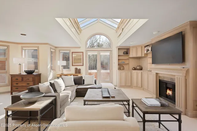 a living room with furniture a large window and a fireplace
