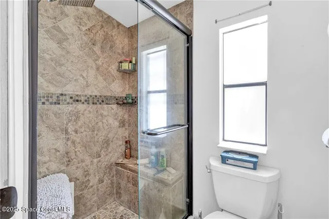 a bathroom with a granite countertop shower a toilet and a sink