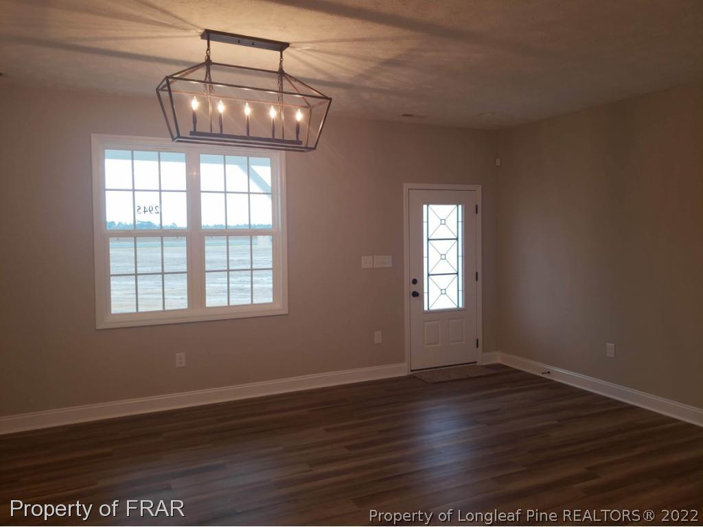 2945 Hayfield Road Wade, NC 28395 - Photo 11 of 26 a view of an empty room with wooden floor and a window