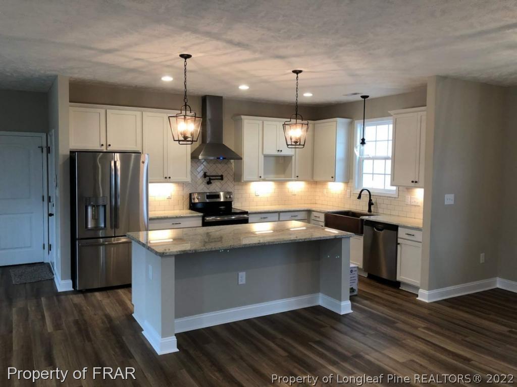 2945 Hayfield Road Wade, NC 28395 - Photo 2 of 26 a kitchen with kitchen island a sink appliances a counter space and a window