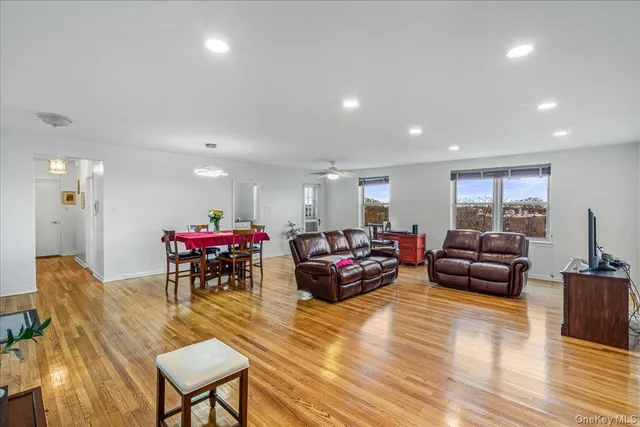 a living room with furniture a flat screen tv and wooden floor