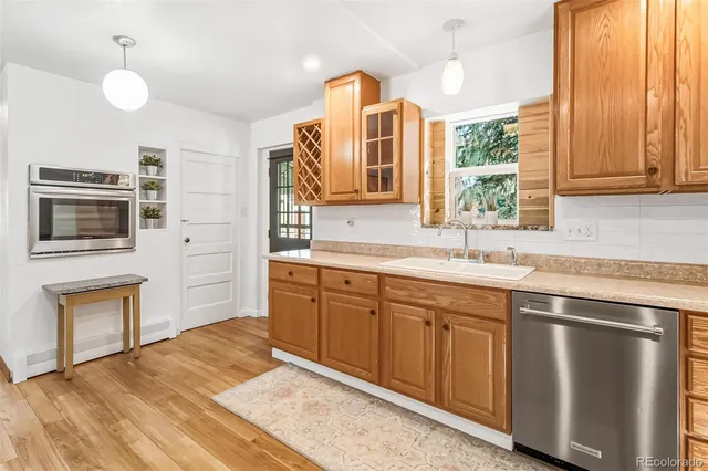 a kitchen with stainless steel appliances granite countertop a sink and dishwasher a stove top oven with wooden floor