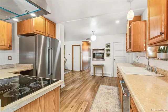 a kitchen with stainless steel appliances granite countertop a sink and a refrigerator
