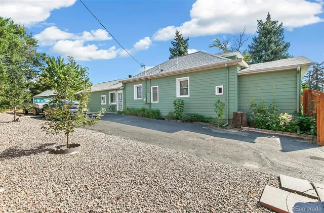 a front view of a house with a yard and potted plants