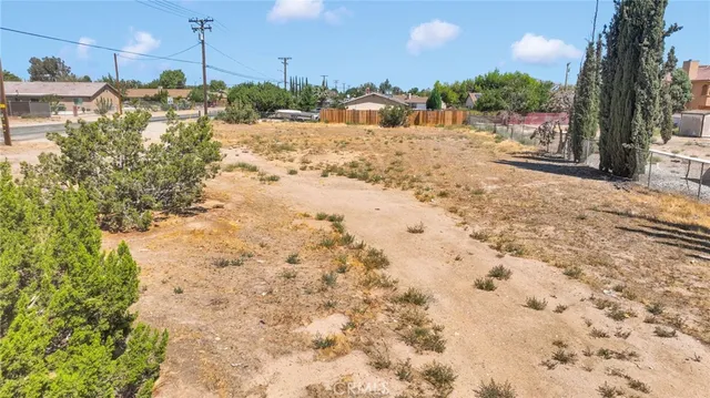 a view of a yard with wooden fence