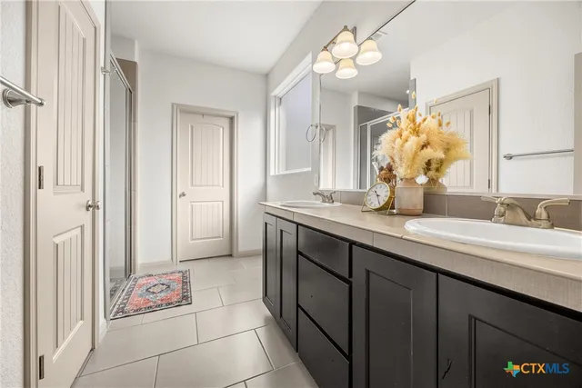 a spacious bathroom with a granite countertop sink a mirror and a shower