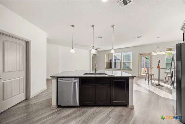 a kitchen with a sink and wooden floor