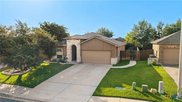 a view of a house with backyard and a tree