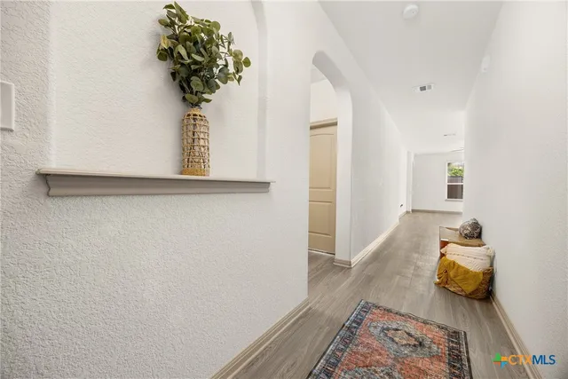 a view of a bedroom with wooden floor and a potted plant