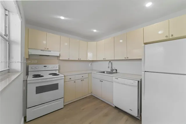 a kitchen with white cabinets and white appliances