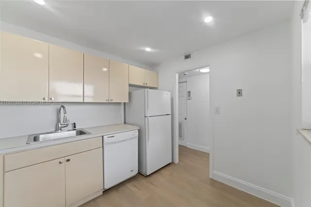 a view of a kitchen with white cabinets