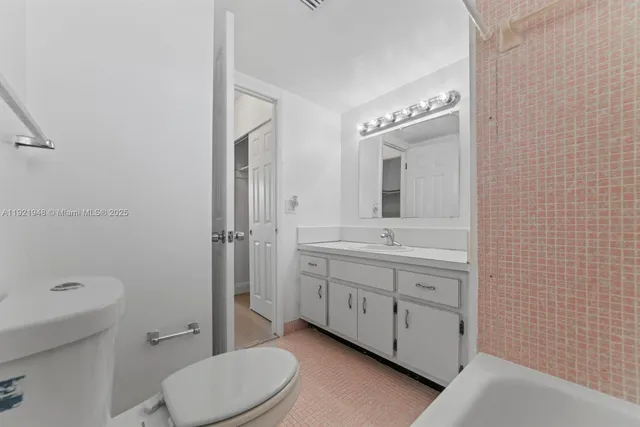 a bathroom with a double vanity sink toilet mirror and shower