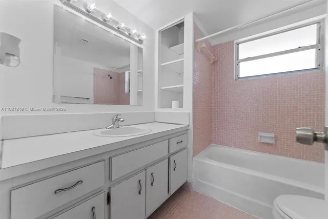 a bathroom with a tub a sink and mirror