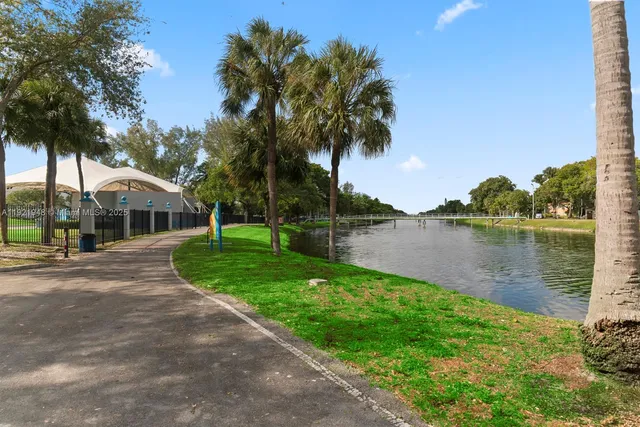 a front view of a house with a yard and potted plants