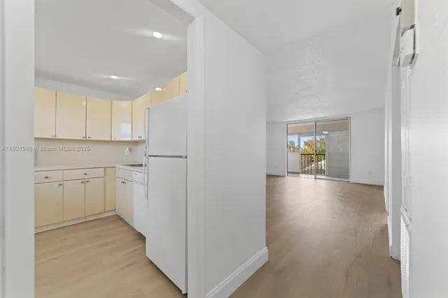 a kitchen with white cabinets and wooden floor