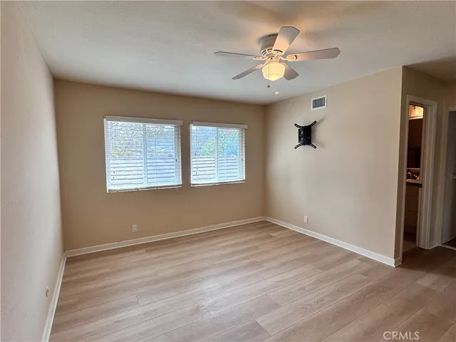 wooden floor fireplace and windows in an empty room