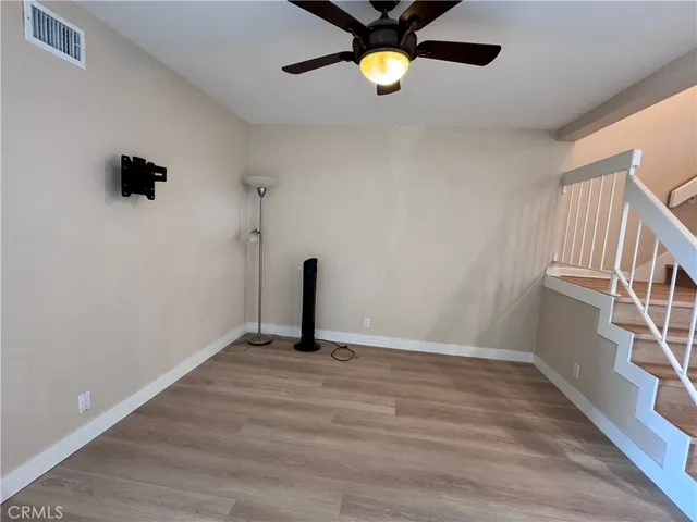 a kitchen with stainless steel appliances granite countertop a refrigerator a sink a stove and a wooden floors