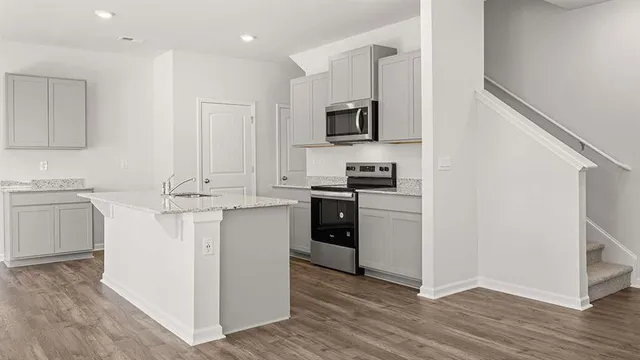 a kitchen with white cabinets and appliances