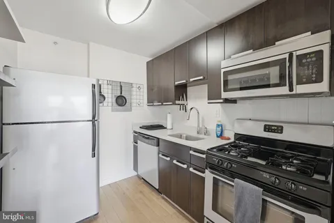 a kitchen with stainless steel appliances granite countertop a stove a refrigerator and a microwave