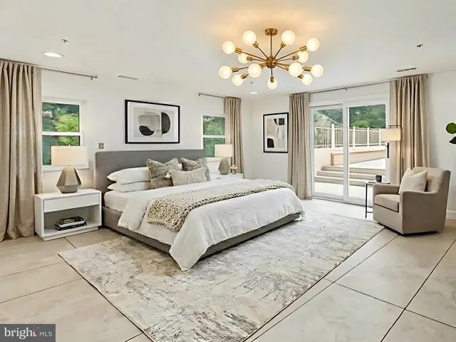a bedroom with a large bed and a chandelier