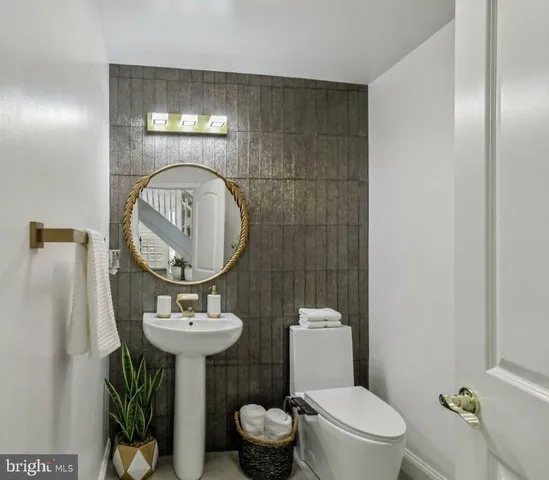 a bathroom with a sink toilet and a mirror