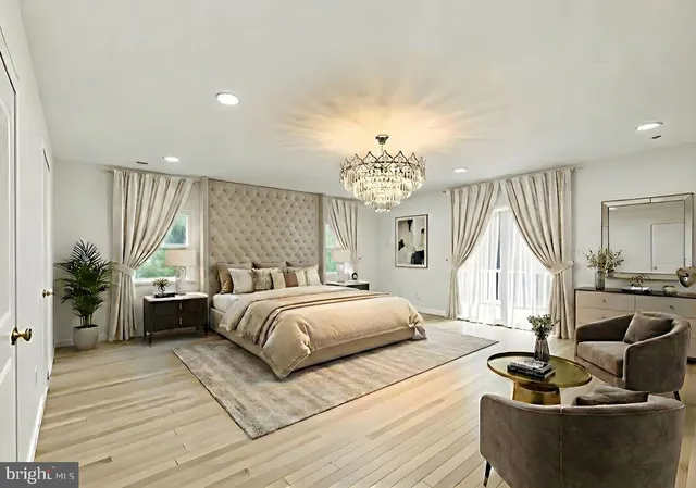a spacious bedroom with a large bed a chandelier and windows