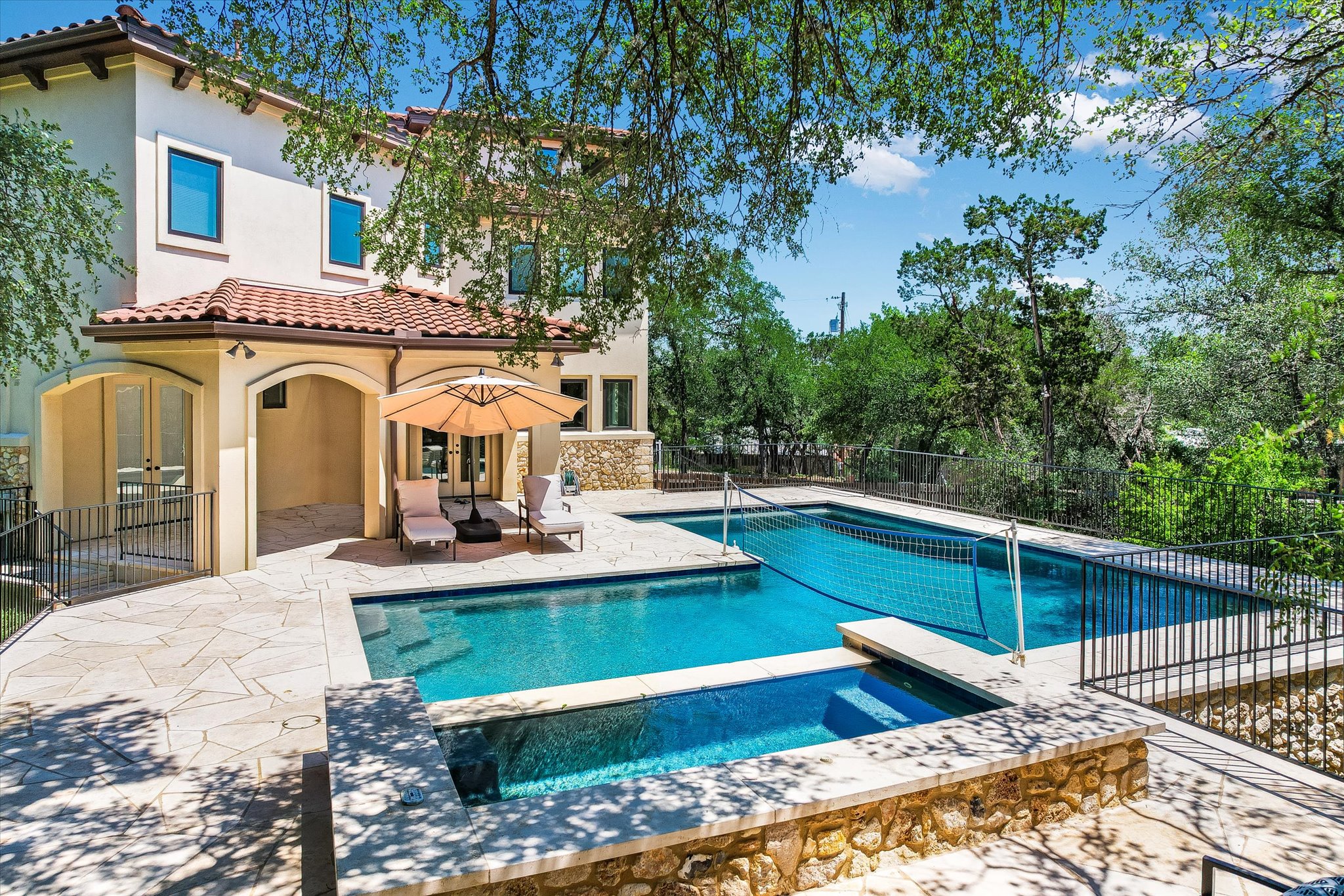 11 Inwood Circle Austin, TX 78746 - Photo 35 of 38 An inviting pool and spa beckon for outdoor enjoyment, framed by lush trees and a stone patio.