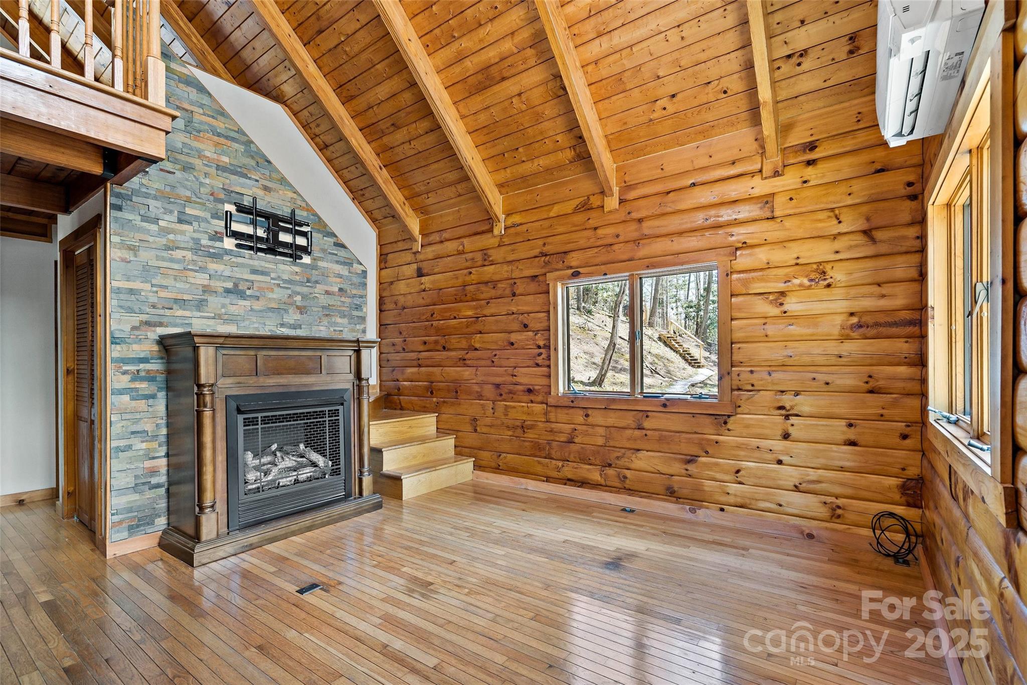 580 Red Dirt Road Newland, NC 28657 - Photo 11 of 48 a view of an empty room with wooden floor and a fireplace