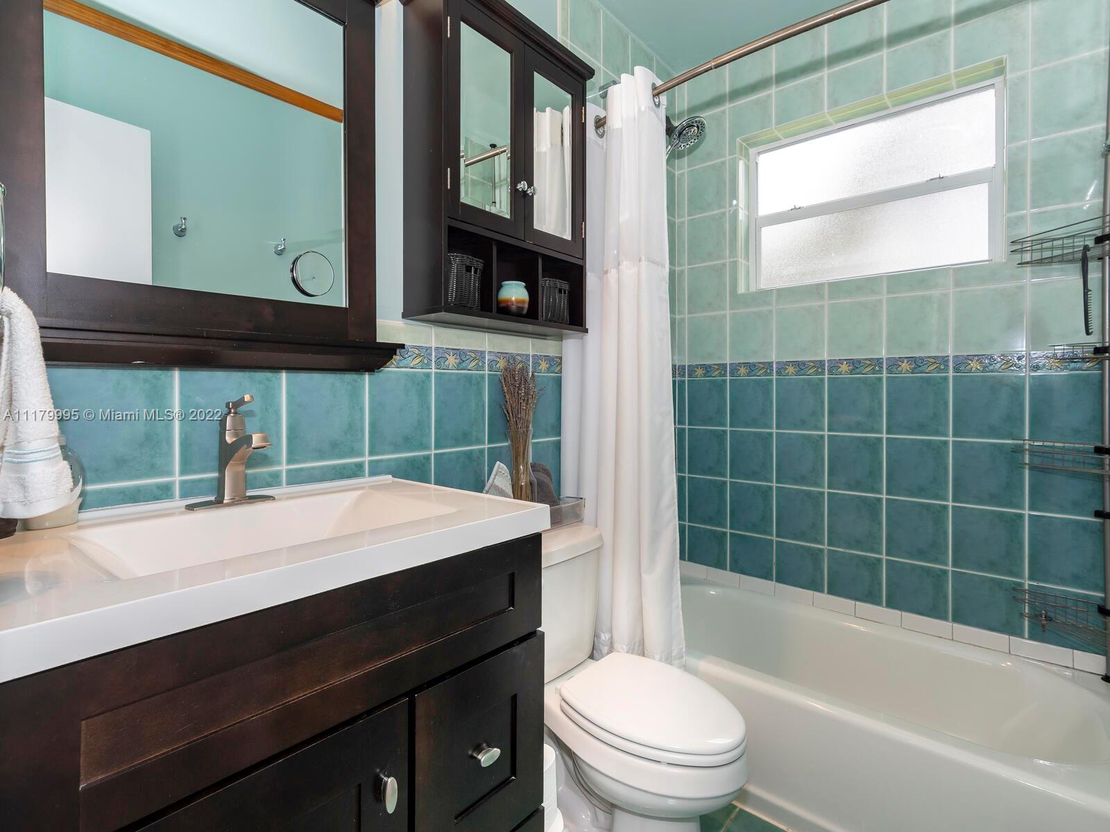 4401 West Park Road Hollywood, FL 33021 - Photo 16 of 23 a bathroom with a sink a toilet a mirror and bathtub