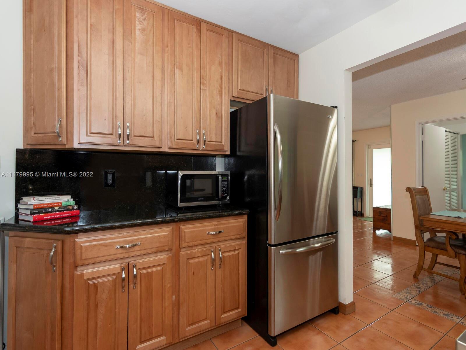 4401 West Park Road Hollywood, FL 33021 - Photo 8 of 23 a kitchen with stainless steel appliances granite countertop a refrigerator a stove and a sink with wooden cabinets