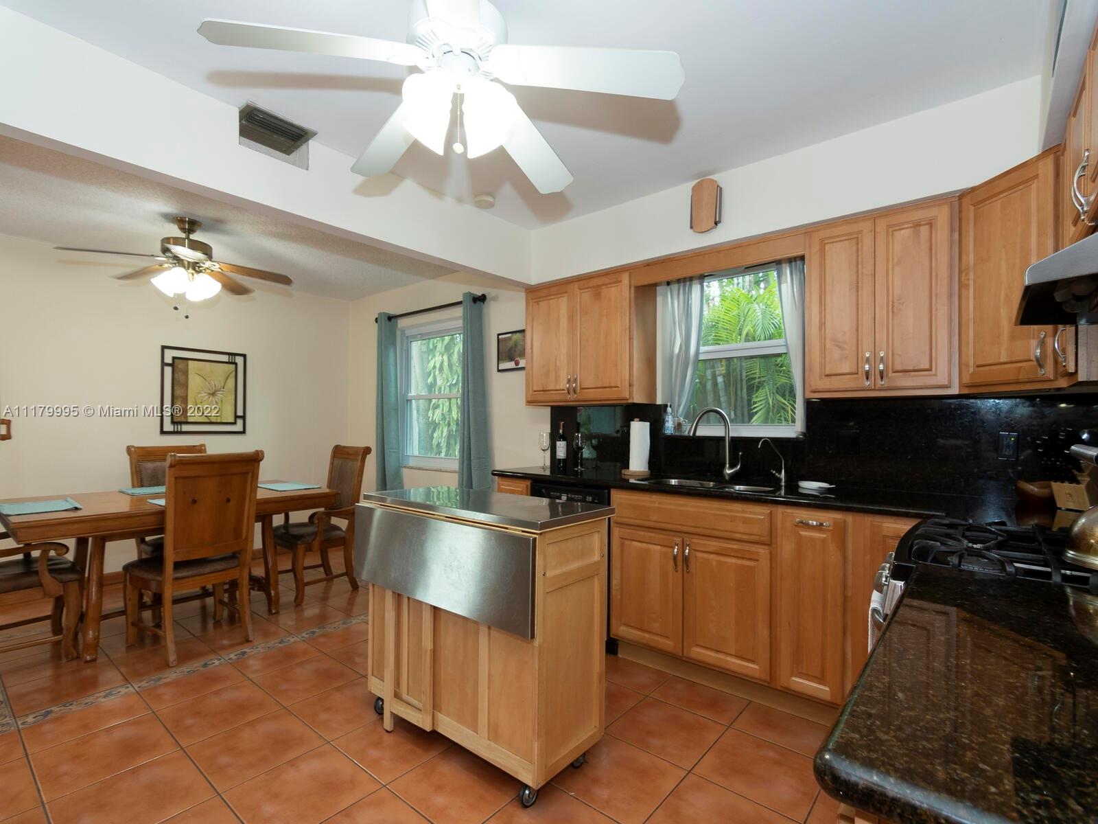 4401 West Park Road Hollywood, FL 33021 - Photo 9 of 23 a kitchen with kitchen island granite countertop a sink counter top space appliances and cabinets