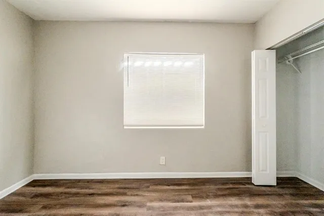 a view of a small space with wooden floor and a window