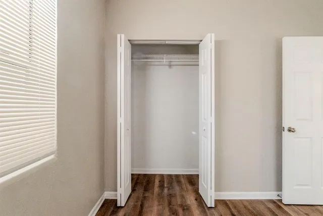 a view of a room with wooden floor and a window
