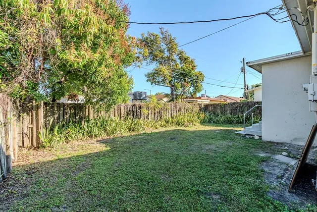 a view of a backyard with wooden fence