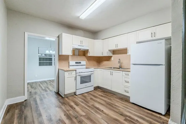 a kitchen with a refrigerator stove and white cabinets