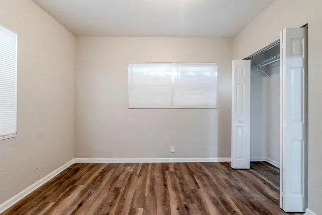 an empty room with wooden floor and mirror