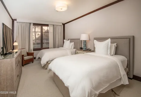 a bedroom with a bed and a flat tv screen on dresser